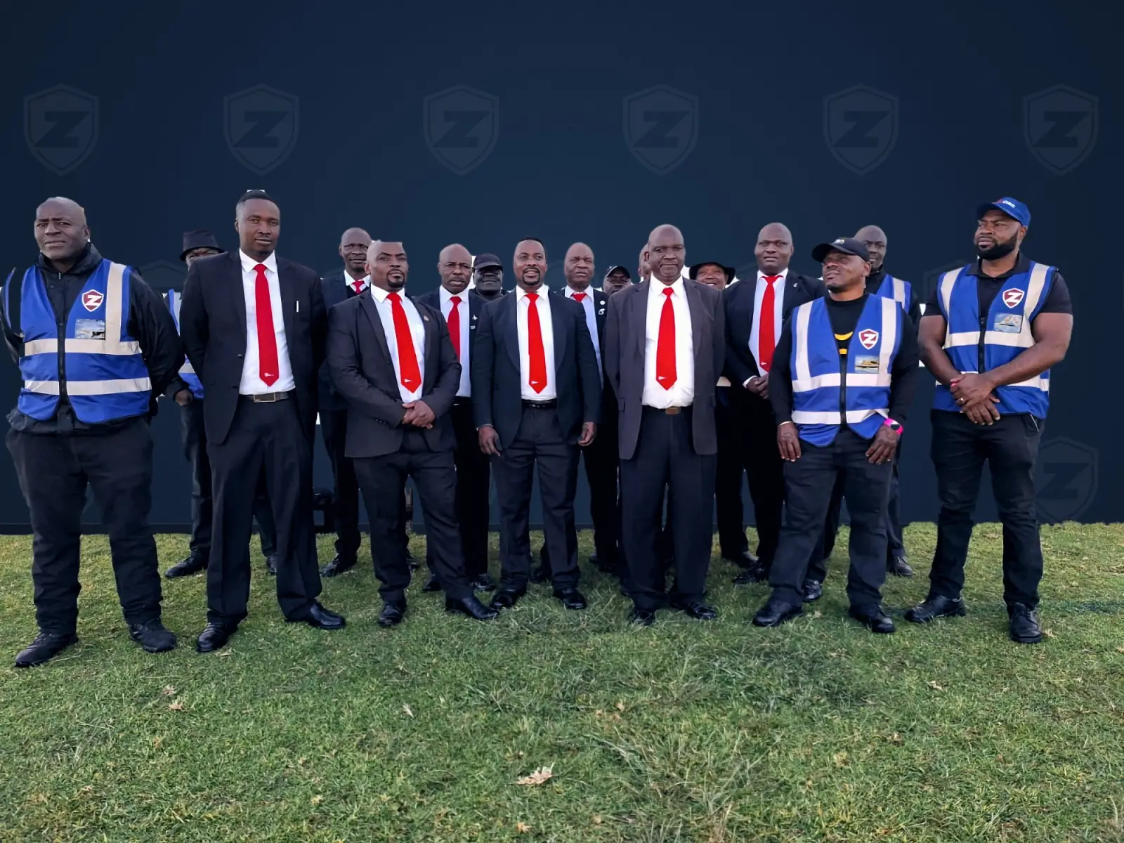 ZENOSC protection team and event security officers together in front of a ZENOSC backdrop on the festival field
