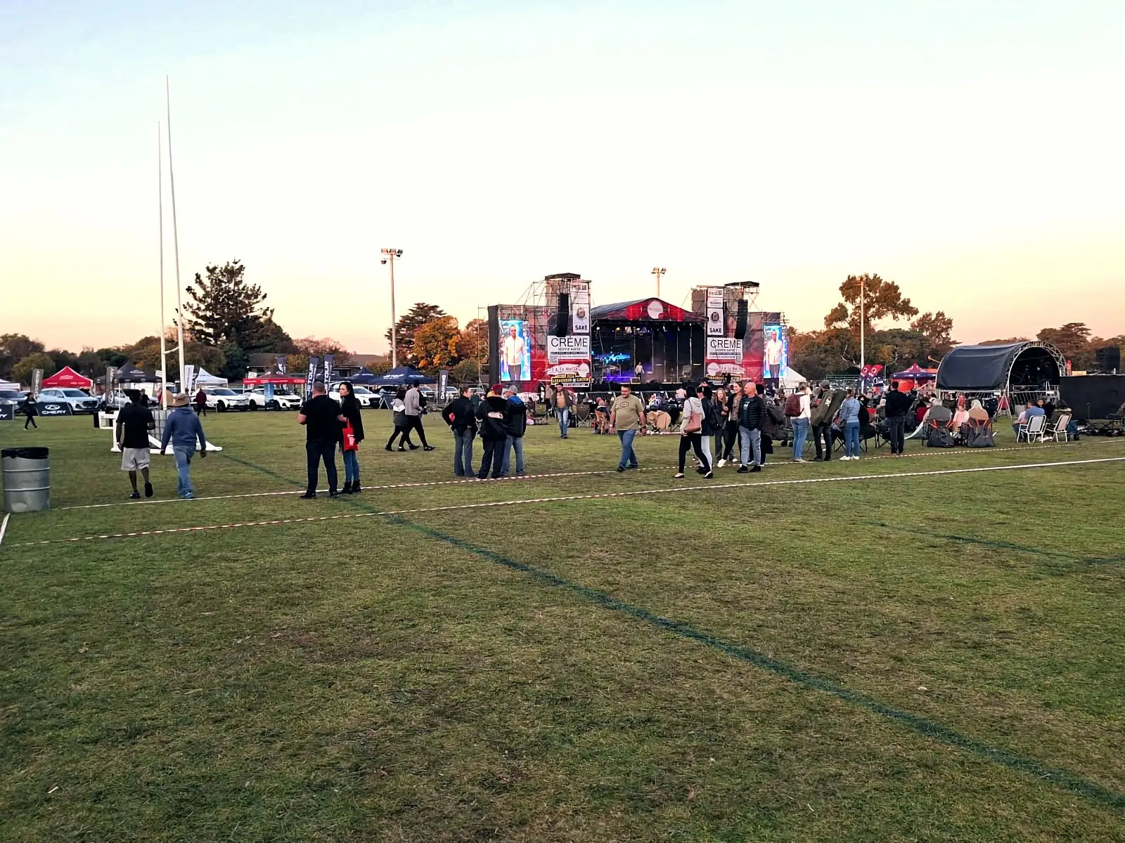 Festival field at sunset with the main stage