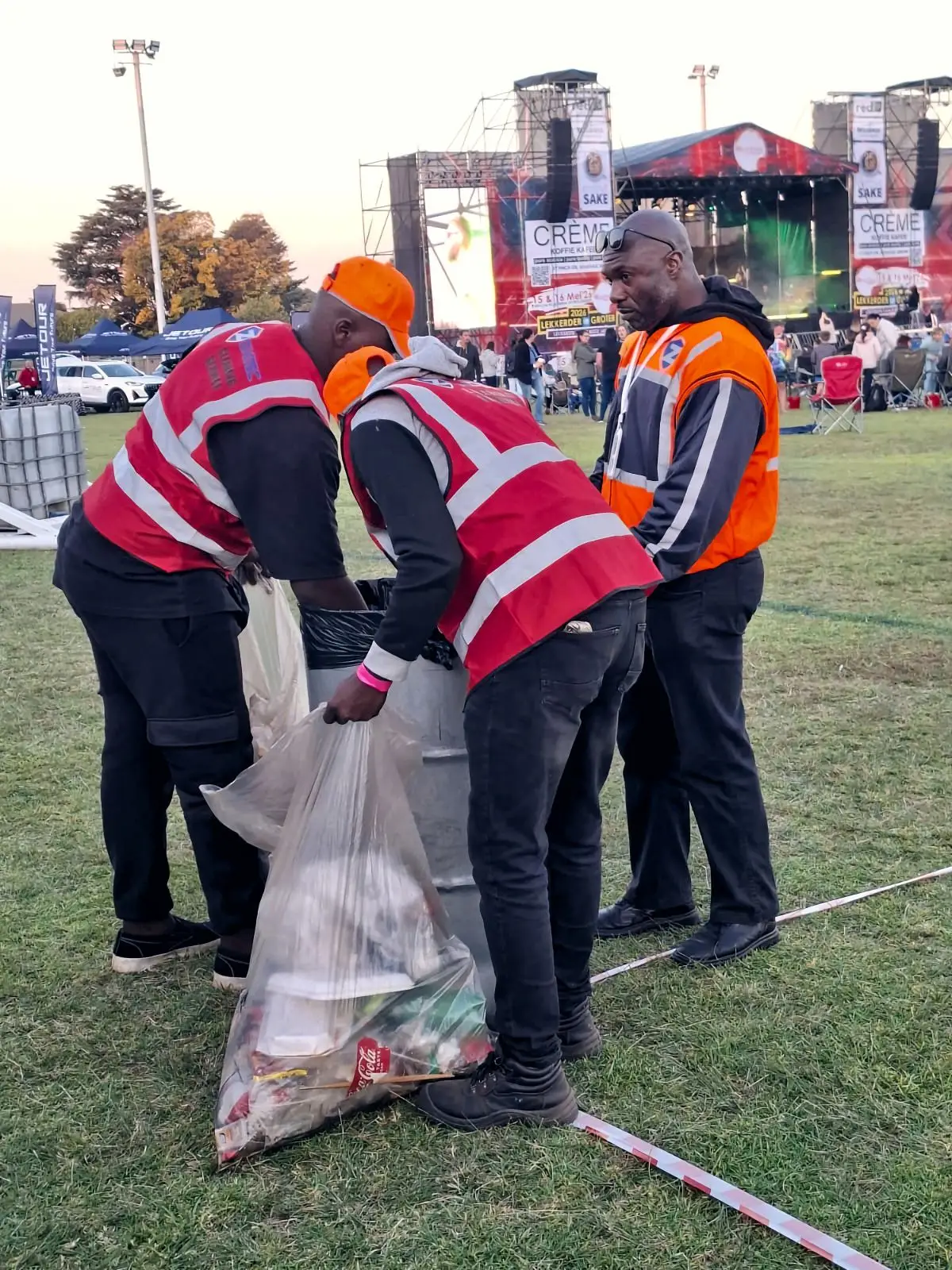 ZENOSC cleaning crew emptying bins in front of the main stage